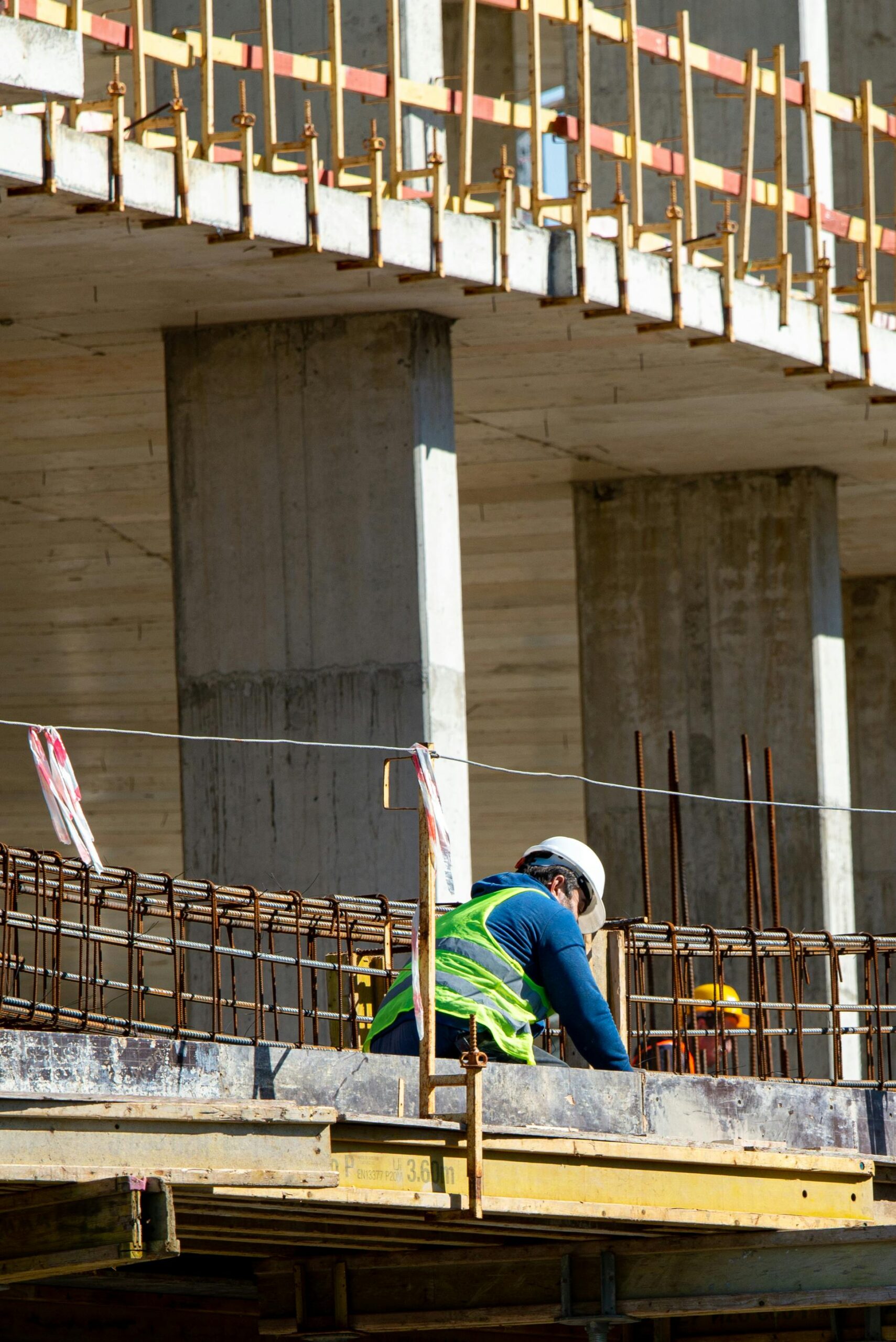 Worker wearing safety gear at construction site, focused on tasks